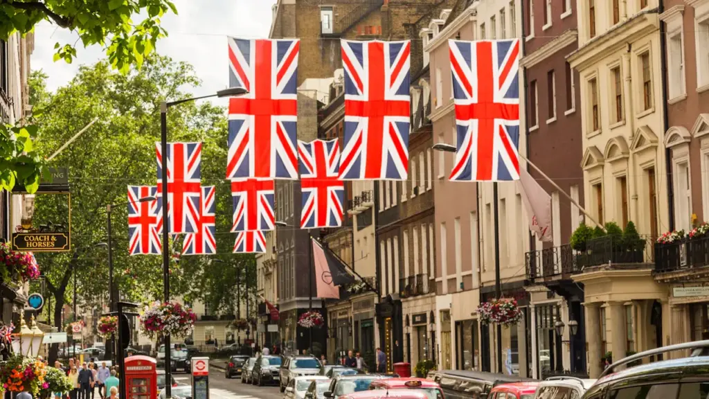 British flags hanging over a bustling street with historic architecture and urban atmosphere