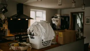 Laundry basket filled with clothes on a wooden counter in a home kitchen