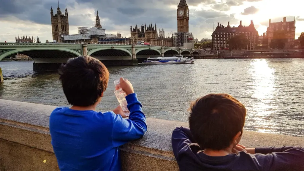 Two boys looking over the River Thames towards Big Ben in London.
