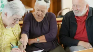 Older adults participating in a collaborative workshop, pointing at a document together.