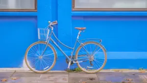 Blue city bike parked neatly beside a bright blue painted urban wall