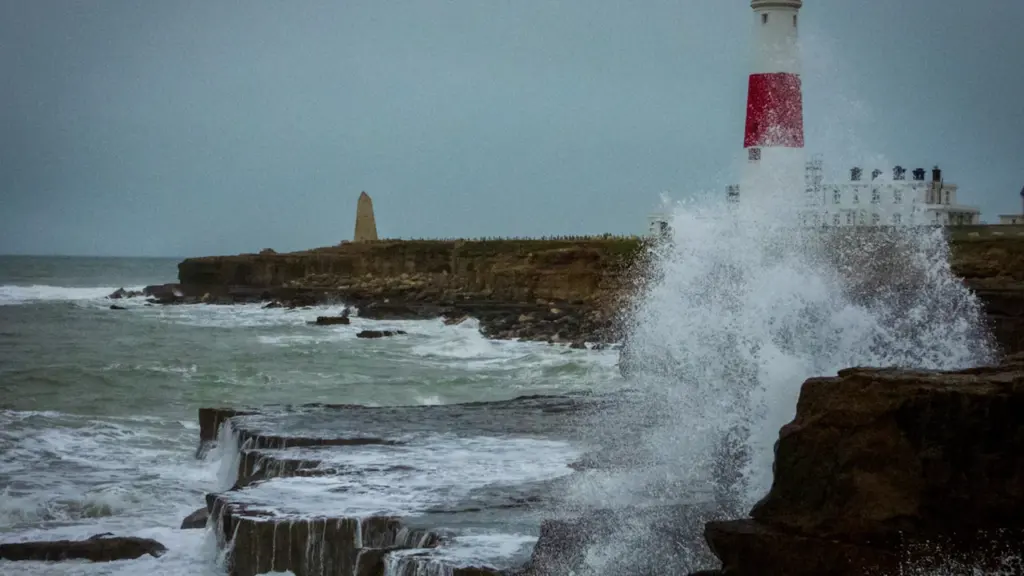Powerful waves crashing against a coastal seawall in Bournemouth, UK.