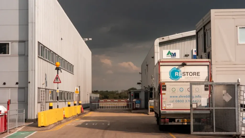 Industrial road near a depot with yellow barriers and a parked truck