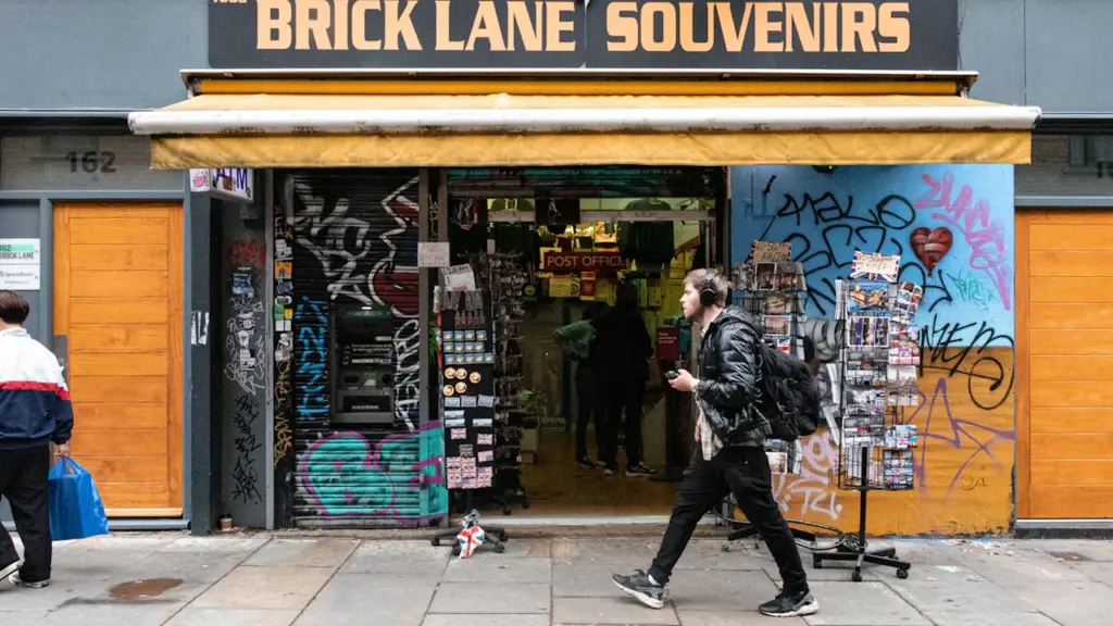 A pedestrian walking past a souvenir shop on a London high street.