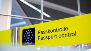 Yellow European passport control signage at an international airport terminal.