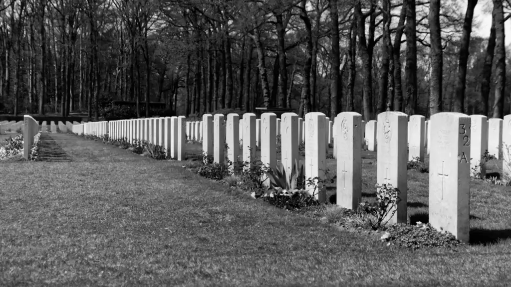 A solemn black and white photograph of a World War II military cemetery.