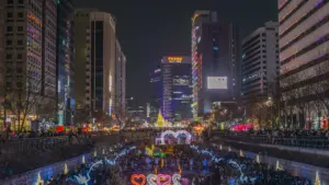 An aerial night view of a glowing, illuminated urban cultural event in Seoul.