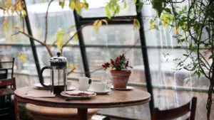 A classic French press and teacup on a wooden table in London.