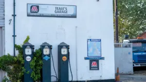Vintage petrol pumps situated outside a local UK independent garage facility.
