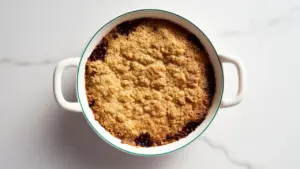 Top-down view of a freshly baked oat crumble in a ceramic dish.