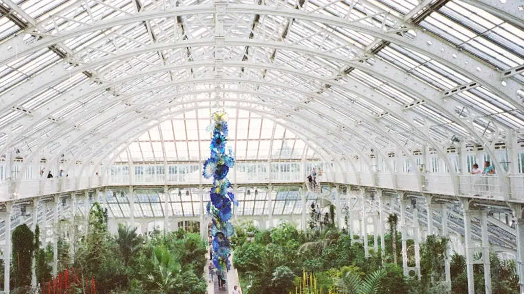 The iconic Palm House at Kew Gardens filled with lush exotic plants.