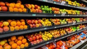 Rows of fresh produce displayed on shelves in a UK supermarket.