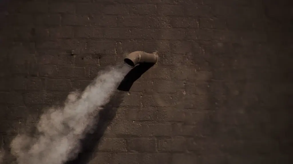Smoke venting from a pipe against a dark brick wall resembling gunpowder fog